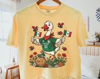 Maskottchen Merlin Comfort Colors® Boxy Crop Tee, Merlin Die Ente und Lady Bugs Shirt, Spieltag Bekleidung, Mexica Frauen Fußball Fan Top