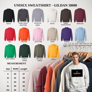 Puede incluir: Exhibici&oacute;n de sudaderas unisex Gildan 18000 en varios colores, como negro, gris, blanco, rojo, naranja y verde. La imagen tambi&eacute;n muestra una tabla de tallas con medidas en cm y una persona con una sudadera blanca con un logotipo.