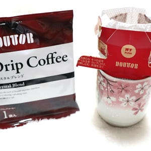 Puede incluir: Un paquete de Doutor Drip Coffee Crystal Blend junto a un filtro de café rojo y blanco y una taza con estampado floral. El paquete de café es rojo oscuro y blanco con texto japonés. El filtro se coloca sobre la taza.