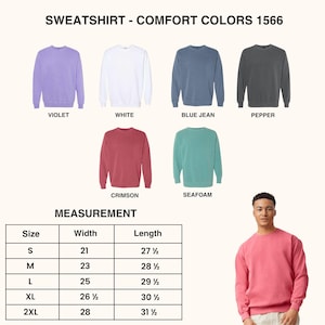 May include: A display of Comfort Colors 1566 sweatshirts in various colors, including violet, white, blue jean, pepper, crimson, and seafoam. A measurement chart is also included, with sizes ranging from S to 2XL, and a person wearing a pink sweatshirt.