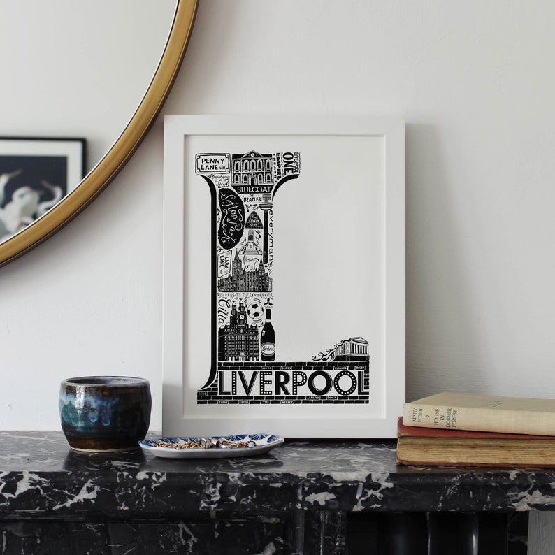 May include: Black and white illustration of the letter L made up of iconic landmarks and symbols from Liverpool, England. The word "Liverpool" is written below the letter.
