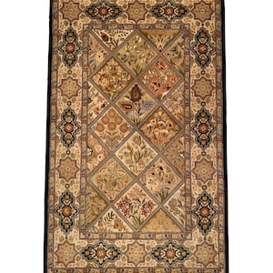 May include: Rectangular rug with a black border and cream-colored background. The rug features a central diamond pattern with floral and geometric designs in shades of brown, green, and red. The border has intricate patterns and fringe.