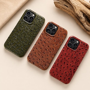 May include: Three leather phone cases in olive green, brown, and burgundy. Each case has a textured surface with small, evenly spaced dimples. The cases are designed to fit a phone with multiple camera lenses.