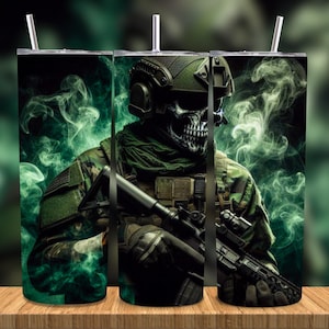 Könnte beinhalten: Ein Edelstahlbecher mit einer digitalen Illustration eines soldatengesichtigen Soldaten in Tarnkleidung, der ein Gewehr hält. Das Design umfasst grüne Raucheffekte vor einem dunklen Hintergrund. Der Becher hat einen Strohhalm und steht auf einer Holzoberfläche.