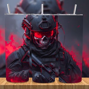 Peut inclure: Un gobelet noir représentant un soldat au visage de crâne en équipement tactique, avec des accents rouges et une expression menaçante. Le design comprend un casque, un casque et un fusil, sur fond sombre et enfumé. Le gobelet a une paille.