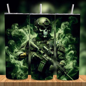 Op de afbeelding: Een roestvrijstalen beker met een soldaat met een schedelgezicht, die een helm en tactische uitrusting draagt en een geweer vasthoudt. Het ontwerp is tegen een achtergrond van groene rook op een zwarte achtergrond. Inclusief een zilveren rietje.