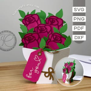 Puede incluir: Un ramo de papel en 3D con cuatro rosas de color rosa oscuro y hojas verdes, envuelto en papel blanco y gris. Una etiqueta rectangular de color rosa brillante cuelga del ramo con el texto blanco "for you" y un pequeño dibujo de corazón.
