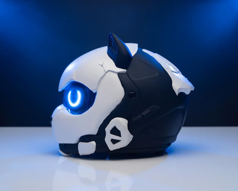 May include: A futuristic helmet in black and white, with a glowing blue eye and accents. The helmet has a sleek, angular design, with a prominent ear and a smooth, reflective surface. The background is a gradient of dark blue.