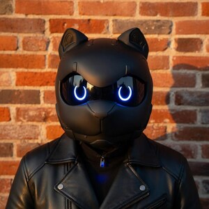 May include: A black cat-shaped helmet with glowing blue eye accents. The helmet is worn with a black leather jacket. The background is a brick wall.