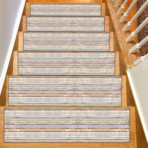 Puede incluir: Peldaños de escalera con un patrón de rayas desgastadas en tonos blancos, beige, azules y morados. Las huellas son rectangulares y están colocadas en escaleras de madera. El diseño añade un elemento decorativo a la escalera.