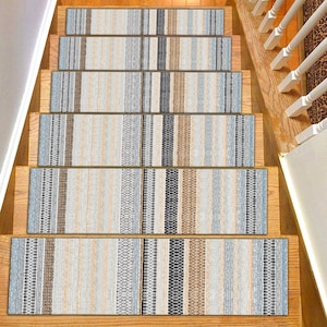 Può includere: Gradini per scale con un motivo a righe nei toni del beige, blu, marrone e nero. I gradini rettangolari coprono i gradini in legno. Il design presenta strisce verticali di larghezze e trame diverse.