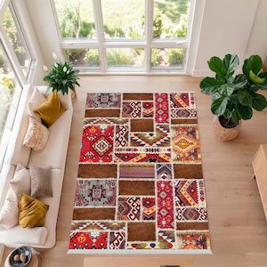 Puede incluir: Una alfombra patchwork con diseños geométricos y tribales en rojo, marrón y crema. La alfombra presenta secciones rectangulares y cuadradas con bordes con flecos, creando un revestimiento de suelo vibrante y texturizado.