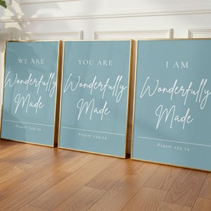 May include: Three framed art prints with a light blue background and gold frames. Each print features the words "We Are", "You Are", and "I Am" above the phrase "Wonderfully Made" in elegant script. The text "Psalm 139:14" is at the bottom.