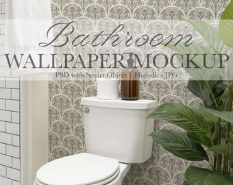 May include: A bathroom scene featuring a white toilet with a closed lid, a roll of white toilet paper, and a brown bottle. The background showcases patterned wallpaper. The text "Bathroom WALLPAPER MOCKUP" is visible.