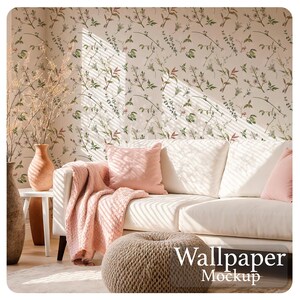Könnte beinhalten: Ein Wohnzimmer mit weißem Sofa, rosa Kissen und einer Decke. Die Wand ist mit floraler Tapete bedeckt. Ein gewebter Hocker und Vasen ergänzen die gemütliche Atmosphäre. Der Text "Wallpaper Mockup" ist sichtbar.