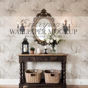 May include: A decorative entryway scene featuring a dark wood console table with two woven baskets below. Above, a gold-framed oval mirror hangs against a floral wallpaper backdrop. The scene includes candles, a lantern, and a vase of white flowers.