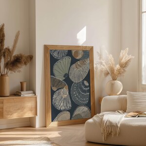 Striped seashell poster in navy, beige, and soft gray with a calm Scandinavian feel, leaning in an airy living room near a wood sideboard and pampas stems.
