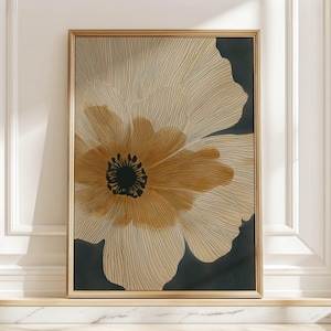Large beige and black linework flower art print with a warm golden center, modern and graphic mood, shown framed leaning on a marble ledge in soft sun.