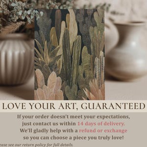 Muted earth-tone cacti and leaf motifs on a dark field, smaller art print standing on a soft surface with blurred ceramic vases and foliage in the background.