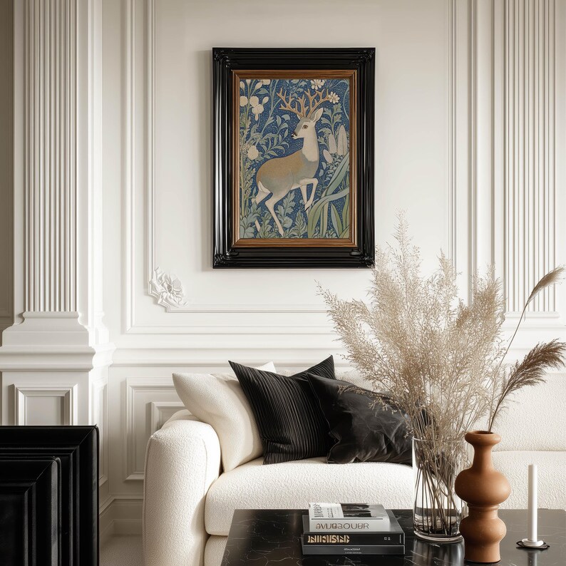 Elegant stag among blue and green foliage art print in a black frame centers an ornate paneled wall above a cream sofa with pampas grass and warm vases.
