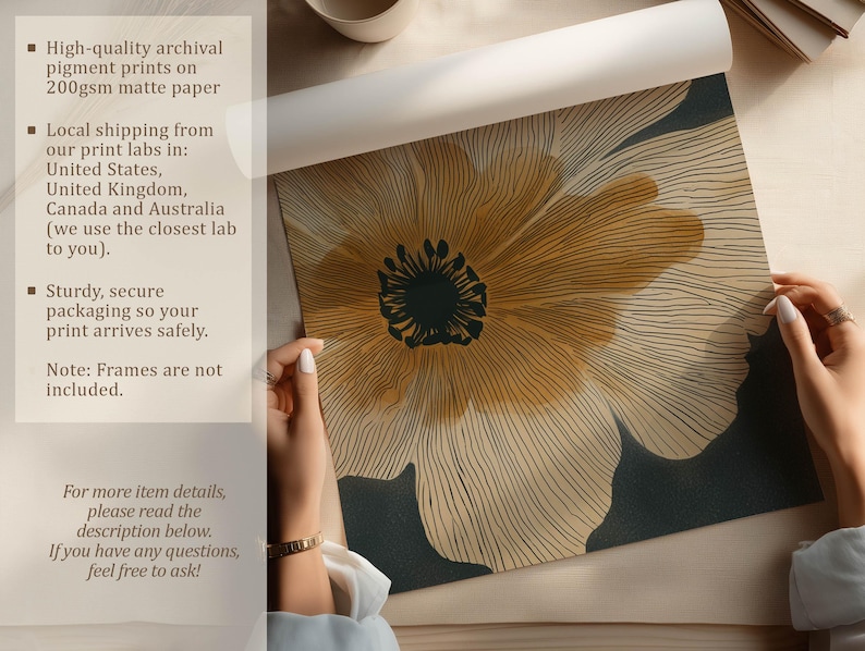 Close-up abstract flower art print in neutral beige and charcoal with golden details, clean modern style, shown being unrolled on a tabletop with paper info overlay.