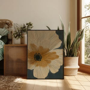 Botanical bloom wall art print in cream, ochre, and charcoal with fine contour lines and a calm modern feel, styled in a cozy bedroom corner by a window.