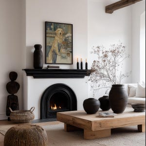 Cozy golden retriever wall art print in watercolor tones, framed above a black fireplace mantel in a neutral living room with a lit fire and woven accents.