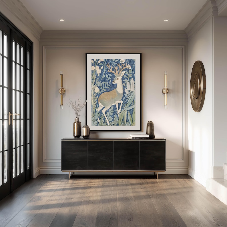 Artful blue deer with tan antlers in a lush floral pattern wall art print is framed above a sleek black console in an elegant entryway with brass accents.