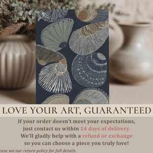 Elegant navy-and-beige seashell wall art print with striped shell details and a serene coastal feel, styled on a tabletop with blurred vases and a guarantee overlay.