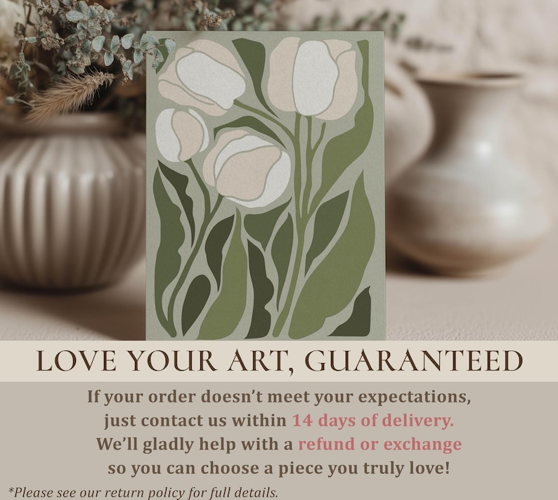 Elegant botanical poster in muted green and cream with a serene mood, large framed poster hanging above a light wood dining table with cane-back chairs and ceramic vases.