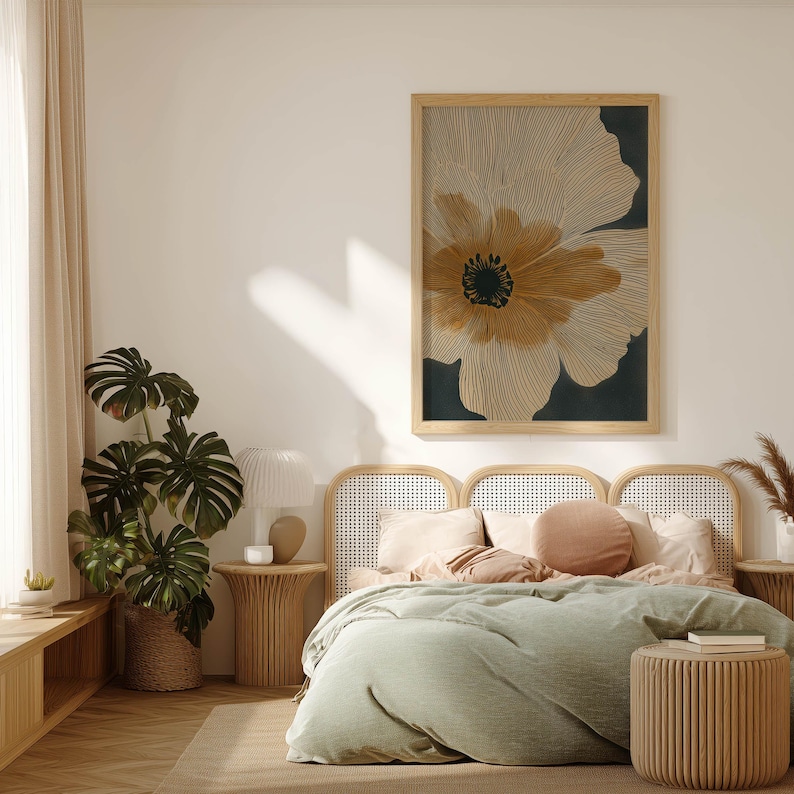 Oversized line-art flower art print in beige and black with warm amber accents, serene modern style, hung above a cane headboard with green bedding.
