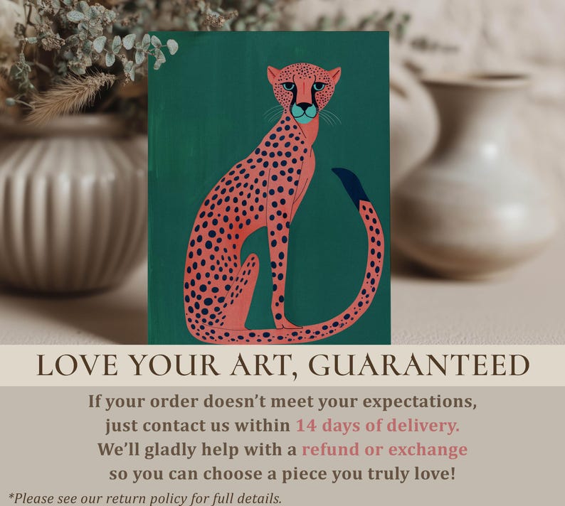 Graphic art print showing a pink cheetah with navy spots on teal, smaller print standing on a soft-toned surface with blurred ceramic vases and a "Love your art, guaranteed" overlay.