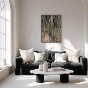 Modern neutral botanical poster with dotted texture and soft lines, framed art print on a soft white wall in a bright living room with a black sofa.