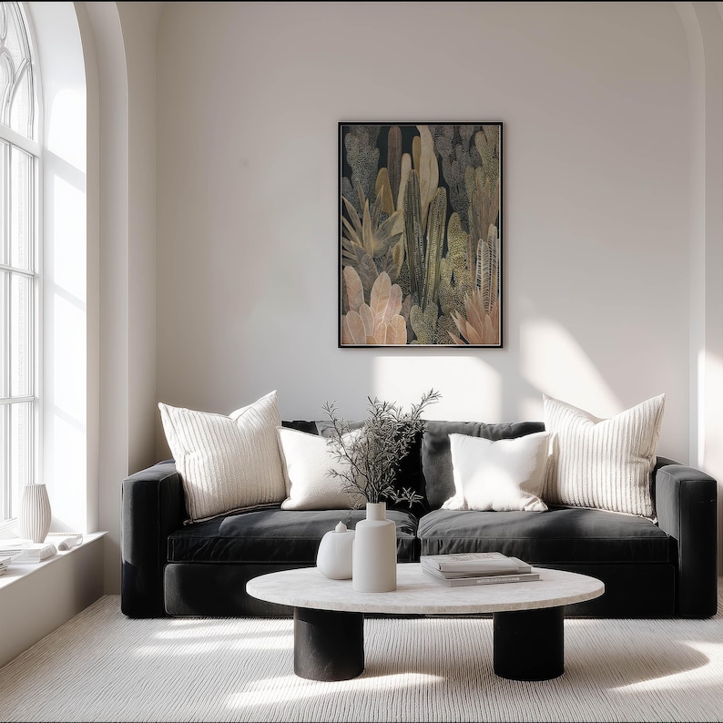 Modern neutral botanical poster with dotted texture and soft lines, framed art print on a soft white wall in a bright living room with a black sofa.