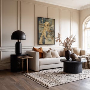 Calm watercolor dog poster above a beige sofa in a warm living room with paneled walls, patterned rug and earthy decorative vases.