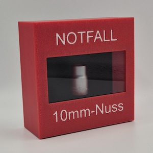 Könnte beinhalten: Eine rote Box mit den Wörtern "NOTFALL" und "10mm-Nuss" in Weiß. Ein kleiner silberner Steckschlüssel ist durch ein rechteckiges Fenster sichtbar. Der Schlüssel ist mit "10 mm" beschriftet.