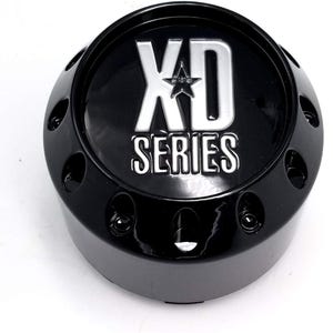 Pu&ograve; includere: Un coprimozzo nero con la scritta "XD SERIES" in argento. Il tappo ha un design a stella sopra la parola "SERIES" ed &egrave; circondato da piccoli fori. Il tappo &egrave; lucido e sembra essere in metallo.