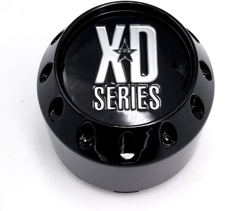 Pu&ograve; includere: Un coprimozzo nero con la scritta "XD SERIES" in argento. Il tappo ha un design a stella sopra la parola "SERIES" ed &egrave; circondato da piccoli fori. Il tappo &egrave; lucido e sembra essere in metallo.