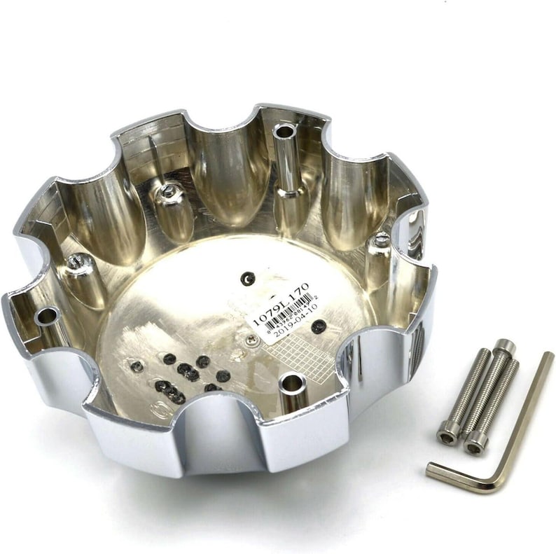 Pu&ograve; includere: Un coprimozzo cromato lucido con un bordo smerlato, con un'indentazione centrale e diversi fori di montaggio. Include tre bulloni e una chiave a brugola. Il coprimozzo ha il testo "1079L 170" e "2019-04-10".