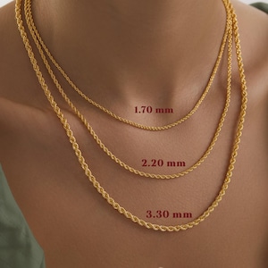 May include: Three gold-colored rope chain necklaces of varying thicknesses are displayed. The thinnest chain is 1.70 mm, the middle chain is 2.20 mm, and the thickest chain is 3.30 mm. The necklaces are worn around the neck.