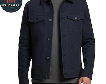 Può includere: Giacca blu navy con chiusura a bottoni, due tasche sul petto e collo. La giacca ha un design classico ed è realizzata in un tessuto resistente. Il logo Wildaura Jacket è visibile nell'angolo in alto a sinistra.