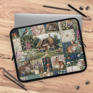 May include: A laptop sleeve featuring a patchwork design with illustrations of rabbits, birds, mushrooms, and a cottage. The sleeve has a black zipper and a variety of floral and nature-themed patterns in pastel colors.