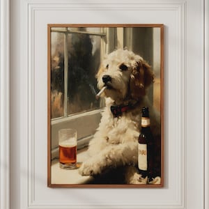 Könnte beinhalten: Ein gerahmter Wandkunstdruck, der einen flauschigen, cremefarbenen Hund mit einer Zigarette im Maul und einem dunklen Halsband zeigt. Der Hund sitzt neben einem Glas mit bernsteinfarbener Flüssigkeit und einer dunklen Flasche auf einem Fensterbrett.