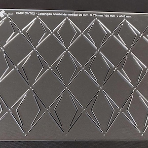 Peut inclure: Une plaque acrylique transparente avec un motif géométrique répétitif de losanges. La plaque présente des motifs découpés en forme de losanges et d'étoiles. Le texte sur la plaque indique "PM01CVT02 - Losanges combinés vertical 90 mm x 70 mm / 90 mm x 43,6 mm" et "www.sellagab.com".
