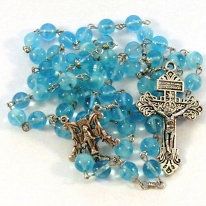 Rosario cattolico fatto a mano con perline di vetro blu fosforescente, crocifisso del perdono indulgente e medaglia centrale mariana.