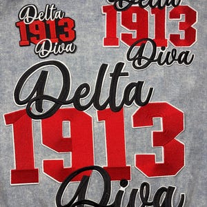 May include: A white ceramic mug with a black handle and the text "But First, Coffee" in a black, handwritten-style font. The mug is on a white surface.