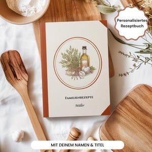 Könnte beinhalten: Ein personalisiertes Rezeptbuch mit braunem Einband und cremefarbenem Deckblatt. Das Deckblatt zeigt eine kreisförmige Illustration von Kräutern, Knoblauch und einer Ölflasche. Der Text "FAMILIENREZEPTE" und "Müller" sind auf dem Cover aufgedruckt.