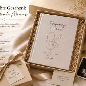 May include: A beige gift box with a pregnancy journal, ultrasound photo, and a small gift. The journal is labeled "Pregnancy JOURNAL" with an illustration of a fetus. The box includes a gift tag and a card. The overall theme is a gift for expectant mothers.
