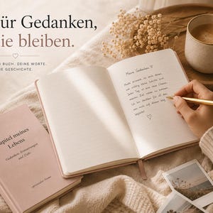 May include: A dusty pink journal with the text 'Kapitel meines Lebens' on the cover, shown open with lined pages and handwritten German text. The journal is accompanied by a gold pen, a ceramic mug, and small photographs on a textured fabric.