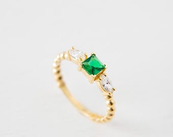 Anello in oro 14 carati con taglio a smeraldo: fascia decorata con perline, gioiello pregiato.